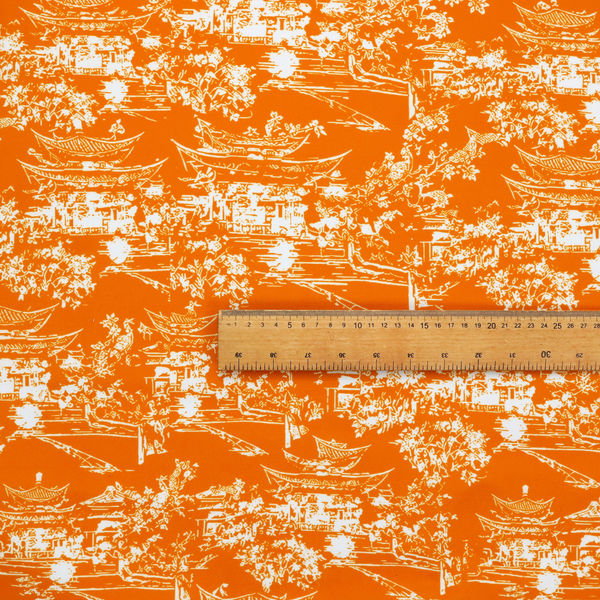 Vibrant orange fabric featuring a white Chinoiserie Toile pattern with pagodas, scenic Asian landscapes, and botanical details.   