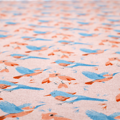 This fabric includes blue and pink birds in various positions on a soft pink background.