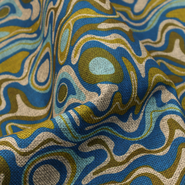 This fabric features different shades of green and beige swirls on a blue background.