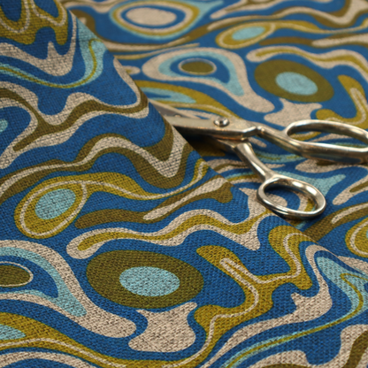 This fabric features different shades of green and beige swirls on a blue background.