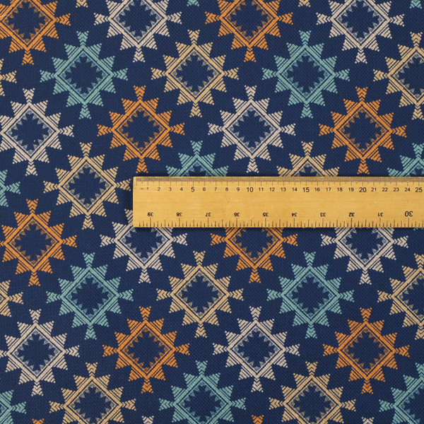 This fabric features repeated geometric shapes in blues, oranges and pinks on a navy blue background.