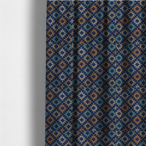 The fabric used to create these made-to-measure curtains, features repeated geometric shapes in blues, oranges and pinks on a navy blue background.