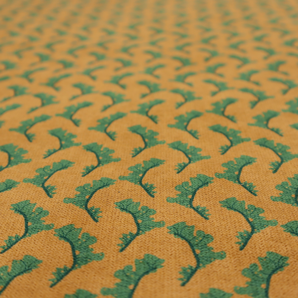 This fabric has a repeated green leaf/floral design on a warm yellow/golden background.
