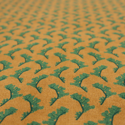 This fabric has a repeated green leaf/floral design on a warm yellow/golden background.