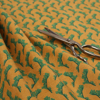 This fabric has a repeated green leaf/floral design on a warm yellow/golden background.
