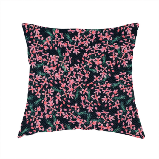 The fabric used to create this homemade cushion is saturated with pink floral bouquets on a deep green background.