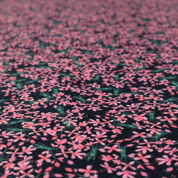 This fabric is saturated with pink floral bouquets on a deep green background.