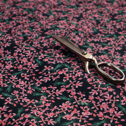This fabric is saturated with pink floral bouquets on a deep green background.
