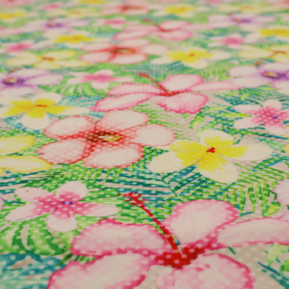 A vibrant tropical fabric pattern featuring pink and purple hibiscus flowers, yellow plumeria, and green palm leaves on a light grey dotted background.