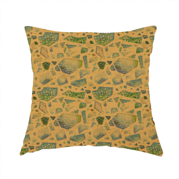This handmade cushion is made with an earthy, abstract fabric pattern featuring organic mosaic shapes in moss green, teal, and slate grey on a textured mustard yellow background.