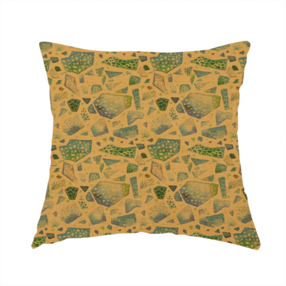 This handmade cushion is made with an earthy, abstract fabric pattern featuring organic mosaic shapes in moss green, teal, and slate grey on a textured mustard yellow background.