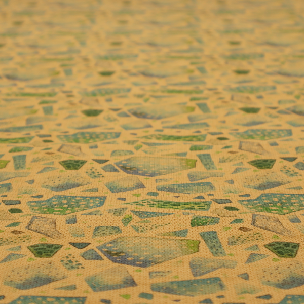 An earthy, abstract fabric pattern featuring organic mosaic shapes in moss green, teal, and slate grey on a textured mustard yellow background.