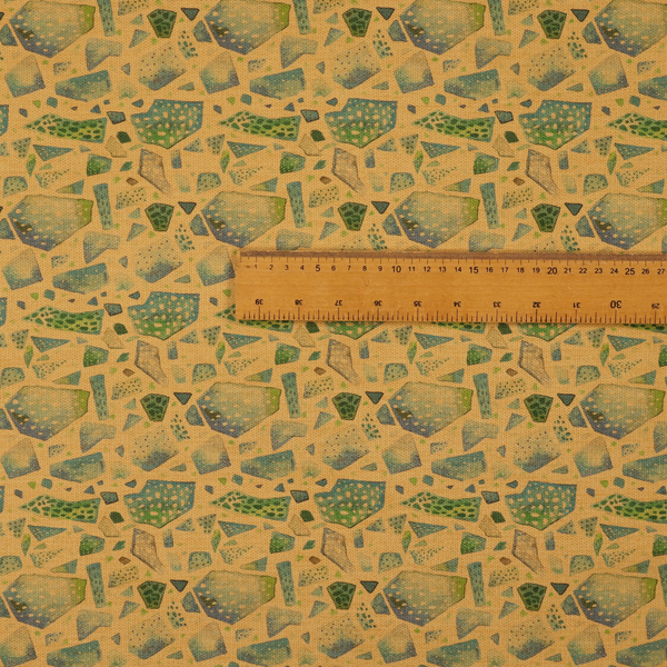 An earthy, abstract fabric pattern featuring organic mosaic shapes in moss green, teal, and slate grey on a textured mustard yellow background.