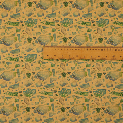 An earthy, abstract fabric pattern featuring organic mosaic shapes in moss green, teal, and slate grey on a textured mustard yellow background.