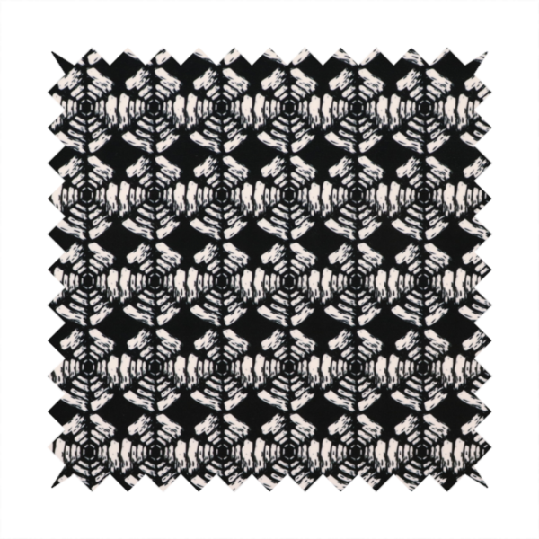 A bold, monochrome fabric pattern featuring a repeating hand-inked radial geometric design in cream on a solid black background.