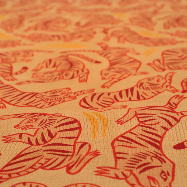Seamless illustrative pattern featuring leaping red tigers on a warm peach-toned background.