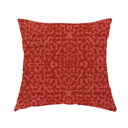 The fabric used to create this handmade cushion is a distressed terracotta red fabric with a symmetrical, abstract medallion pattern and a weathered, block-print texture.