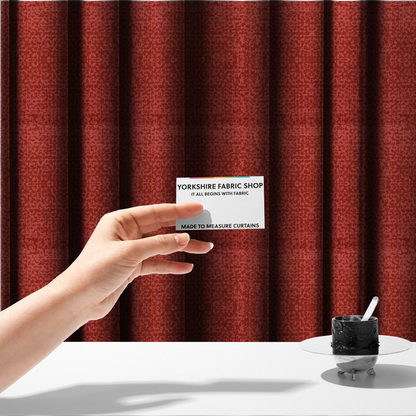 The fabric used to create these made-to-measure curtains is a distressed terracotta red fabric with a symmetrical, abstract medallion pattern and a weathered, block-print texture.