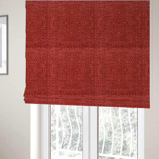 The fabric used to create these bespoke Roman blinds is a distressed terracotta red fabric with a symmetrical, abstract medallion pattern and a weathered, block-print texture.