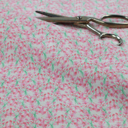 Vertical pink floral branch pattern on white fabric, featuring a delicate blossom and green stem motif.