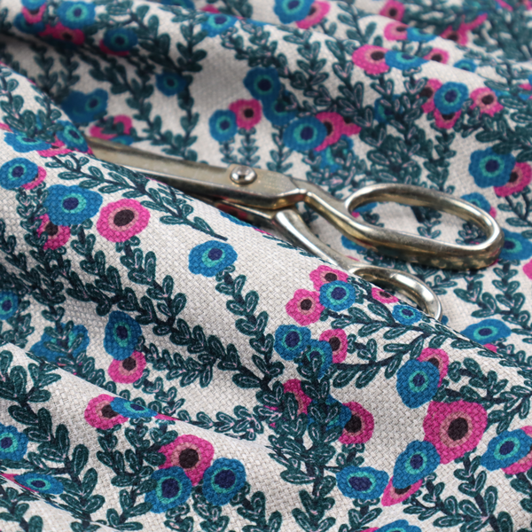 A patterned upholstery fabric with a visible cross-weave texture. The design features a repetitive botanical motif of teal vines and multi-coloured pink and blue flowers on a neutral cream base.