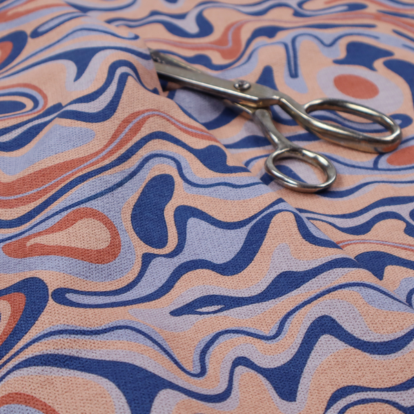 A repeating textile design with a psychedelic, mid-century modern aesthetic. The pattern consists of flowing, organic "liquid" lines and nested concentric shapes resembling a topographical map or marbleized paper. Colours include deep navy blue, warm terracotta, soft peach, and periwinkle.