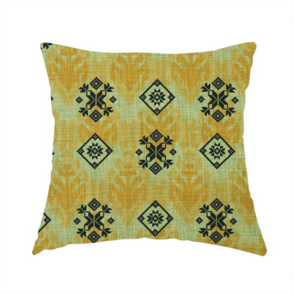 The fabric used to create this handmade cushion has a seamless geometric pattern featuring black and charcoal medallions over a textured yellow and olive green ikat background.