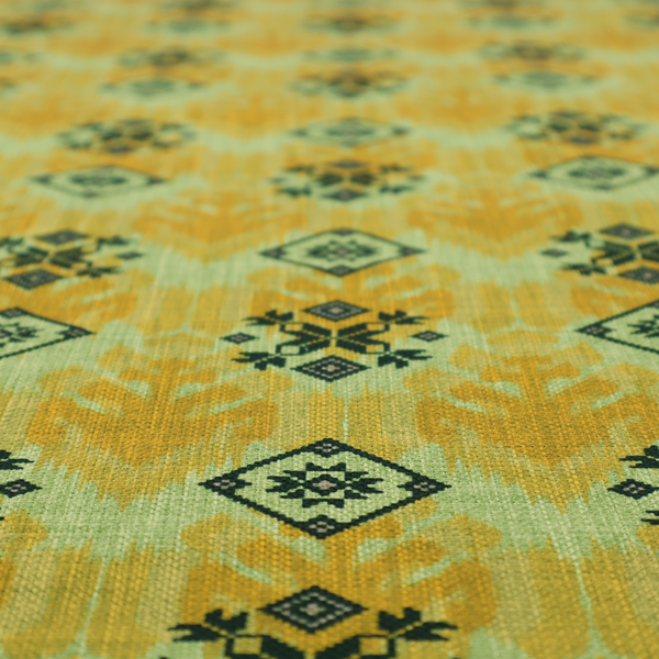 Seamless geometric pattern featuring black and charcoal medallions over a textured yellow and olive green ikat background.