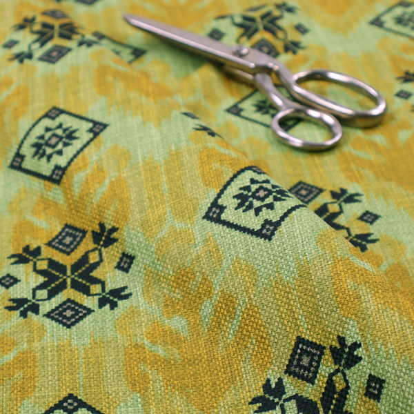 Seamless geometric pattern featuring black and charcoal medallions over a textured yellow and olive green ikat background.