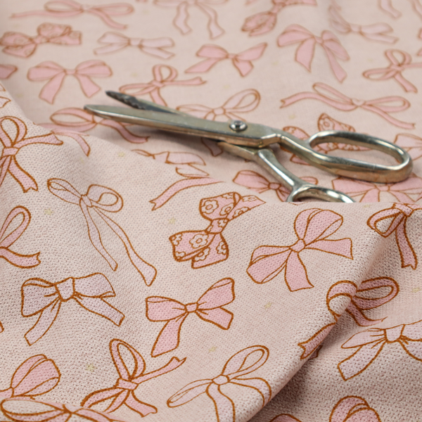 This fabric includes different shapes and styles of pink bows on a pink background.