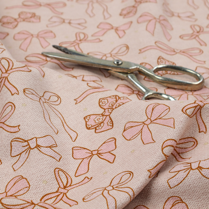 This fabric includes different shapes and styles of pink bows on a pink background.