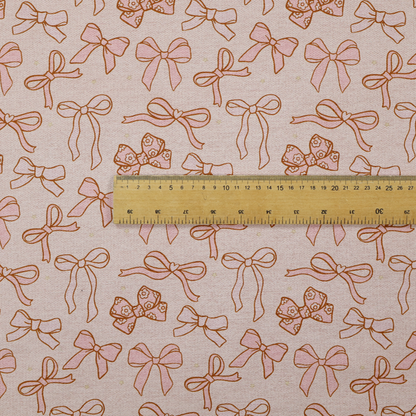 This fabric includes different shapes and styles of pink bows on a pink background.