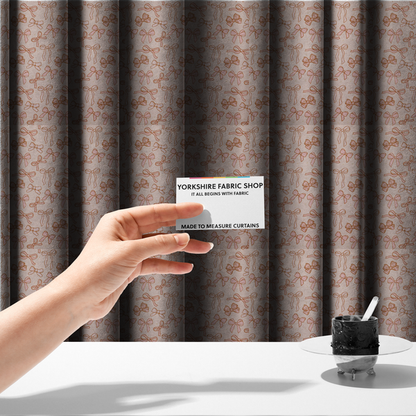 The fabric used to create these made-to-measure curtains includes different shapes and styles of pink bows on a pink background.