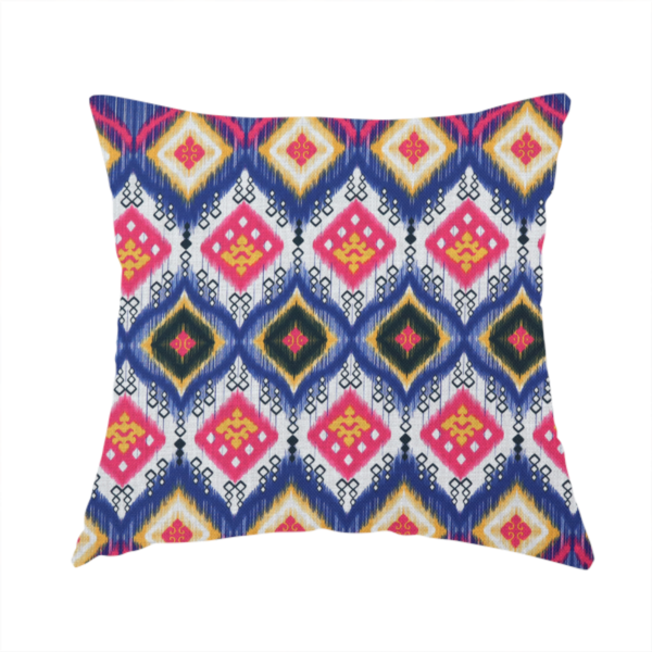 The fabric used to create this handmade cushion is a high-energy textile with a large-scale geometric Ikat design. The pattern showcases concentric diamonds with feathered, "blurred" edges in electric blue, bright pink, and yellow, set against a background with vertical white striations.