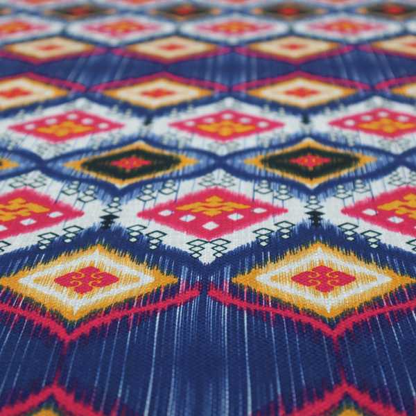 A high-energy textile with a large-scale geometric Ikat design. The pattern showcases concentric diamonds with feathered, "blurred" edges in electric blue, bright pink, and yellow, set against a background with vertical white striations.