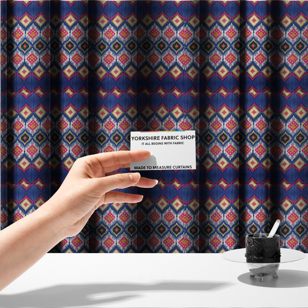 The fabric used to create these made-to-measure curtains is a high-energy textile with a large-scale geometric Ikat design. The pattern showcases concentric diamonds with feathered, "blurred" edges in electric blue, bright pink, and yellow, set against a background with vertical white striations.