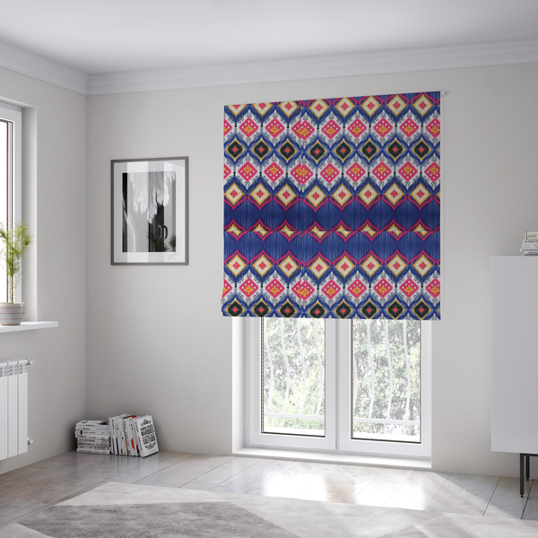 The fabric used to create these bespoke Roman blinds is a high-energy textile with a large-scale geometric Ikat design. The pattern showcases concentric diamonds with feathered, "blurred" edges in electric blue, bright pink, and yellow, set against a background with vertical white striations.