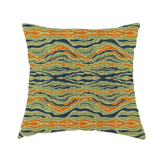 The fabric used to create this handmade cushion is a woven fabric featuring a repeating horizontal wavy pattern in burnt orange, navy blue, and sage green.