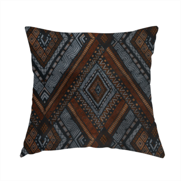 The fabric used to create this handmade cushion is a intricate textile design with a repeating diamond and chevron motif. The pattern features fine, hand-inked linework, including Greek key patterns and zig-zags. The colour palette is a moody mix of earthy terracotta, deep grey, and black, giving it a rustic, bohemian feel.