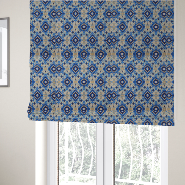 The fabric used to create these bespoke Roman blinds is a repeating textile pattern featuring ornate blue Ikat medallions with a feathered, hand-painted appearance. The design includes smaller navy diamonds and sandy beige geometric shapes set against a light oatmeal-coloured fabric texture.