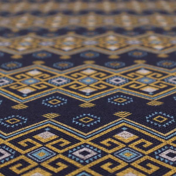 A horizontal Southwestern-inspired geometric pattern featuring navy blue bands with mustard yellow and sky blue interlocking diamonds and Greek key motifs.
