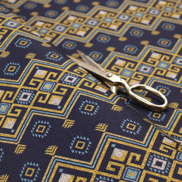 A horizontal Southwestern-inspired geometric pattern featuring navy blue bands with mustard yellow and sky blue interlocking diamonds and Greek key motifs.