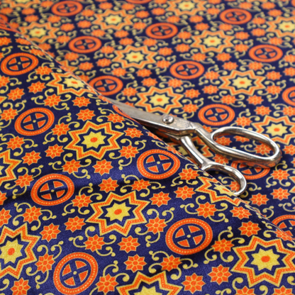 A repeating celestial geometric pattern featuring eight-pointed orange stars and circular cross motifs set against a deep navy blue background with yellow filigree.