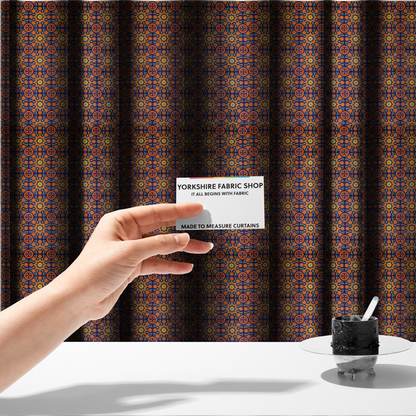 The fabric used to create these made-to-measure curtains is a repeating celestial geometric pattern featuring eight-pointed orange stars and circular cross motifs set against a deep navy blue background with yellow filigree.