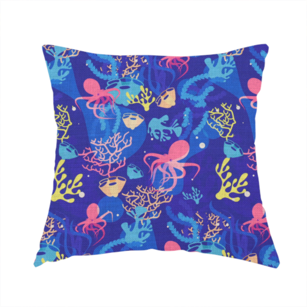 The fabric used to create this handmade cushion is a vibrant nautical pattern featuring pink octopuses, yellow coral branches, and textured sea sponges set against an electric indigo blue background.