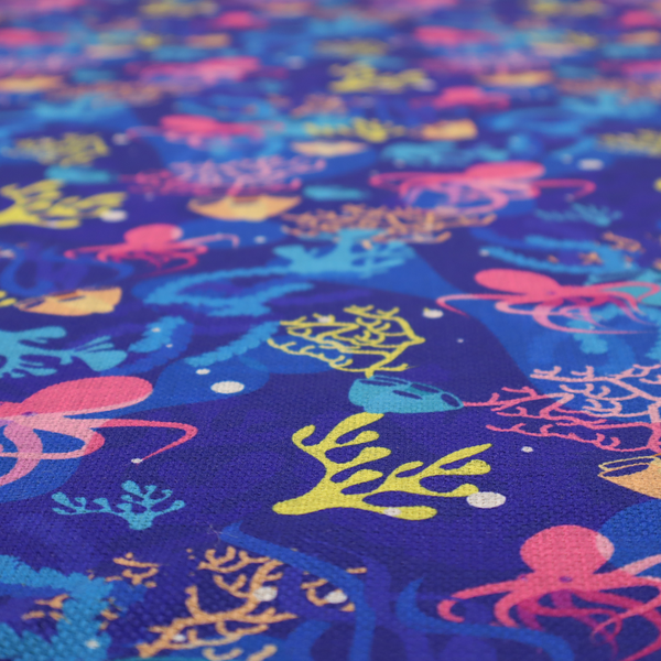 A vibrant nautical pattern featuring pink octopuses, yellow coral branches, and textured sea sponges set against an electric indigo blue background.