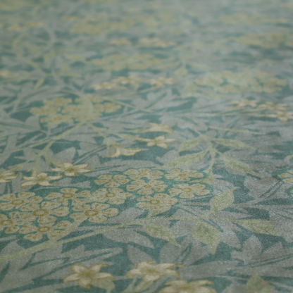 Muted green textile print with a complex, repeating botanical motif. The design features tightly packed five-petal flower clusters and delicate willow-like leaves in shades of dusty sage, teal, and pale lime green.