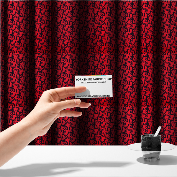 The fabric used to create these made-to-measure curtains is a repeating psychedelic pattern of vibrant red melting smiley faces and abstract kidney shapes set against a dark black background.