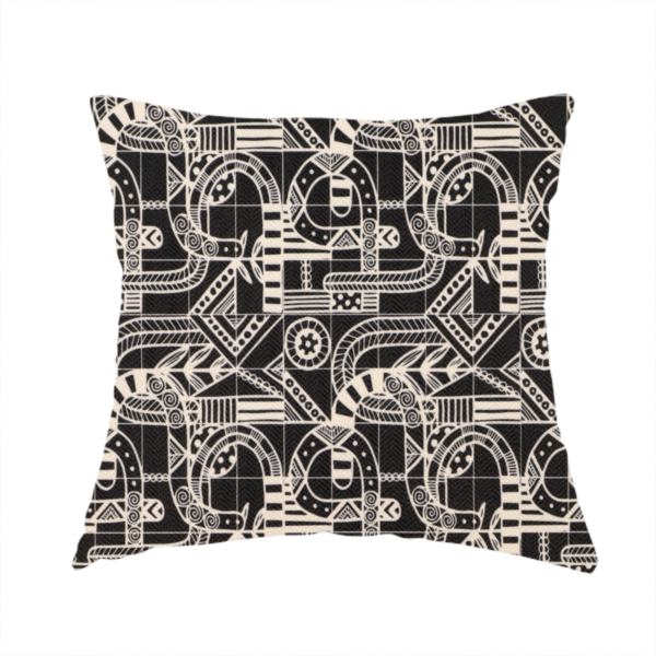 The fabric used to create this handmade cushion is an intricate black and white repeating pattern featuring a grid of tribal-inspired geometric motifs. The design displays stylized, interlocking serpentine and curved forms filled with detailed line work, dots, and hatch marks. Circular gear-like symbols and triangular accents create a structured, rhythmic composition with a high-contrast, hand-drawn aesthetic on a textured fabric.