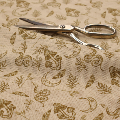 A light beige fabric featuring a repetitive boho-mystical pattern. The design is printed in a muted olive-brown ink and includes the following hand-drawn elements scattered across the material.